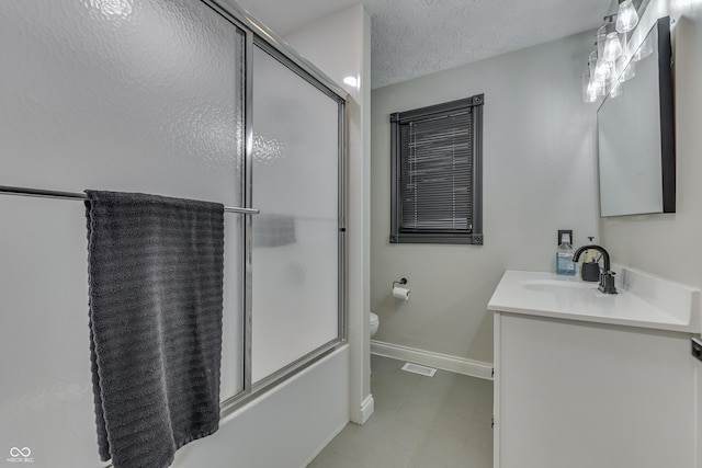 full bathroom featuring vanity, toilet, combined bath / shower with glass door, and a textured ceiling