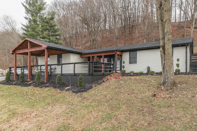 view of front of house featuring a front lawn and a wooden deck