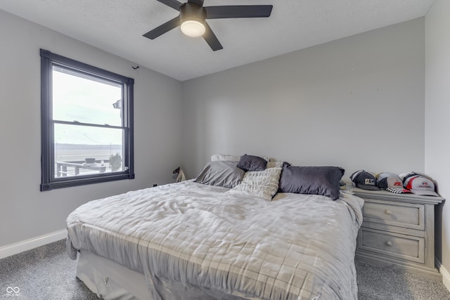 bedroom featuring carpet flooring, ceiling fan, and a textured ceiling