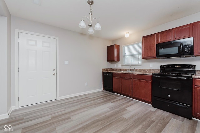 kitchen featuring black appliances, decorative light fixtures, light hardwood / wood-style floors, and a chandelier