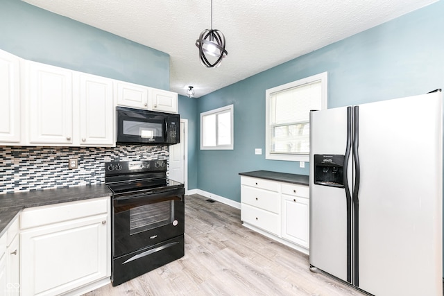 kitchen featuring black appliances, white cabinets, hanging light fixtures, light wood-type flooring, and a textured ceiling