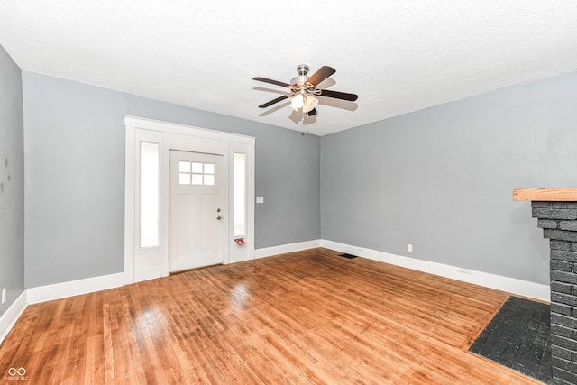 3458 N Kenwood Ave, Indianapolis, IN 46208 - foyer with wood finished floors, a ceiling fan, a fireplace with flush hearth, and a textured ceiling