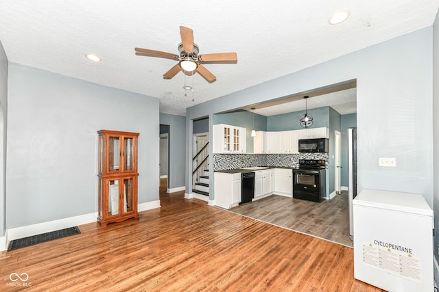 3458 N Kenwood Ave, Indianapolis, IN 46208 - kitchen with black appliances, a ceiling fan, light wood-style flooring, white cabinets, and backsplash