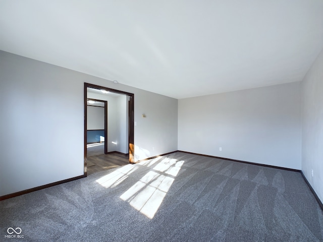 spare room featuring dark colored carpet