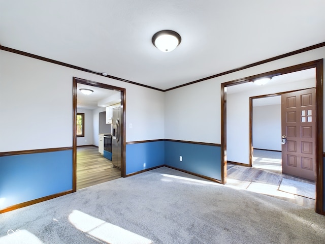 unfurnished room with light wood-type flooring and crown molding