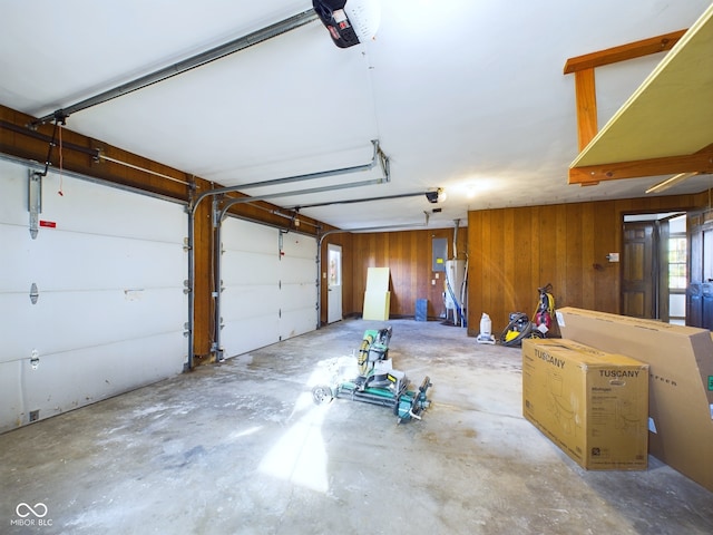 garage featuring electric panel, a garage door opener, and wooden walls