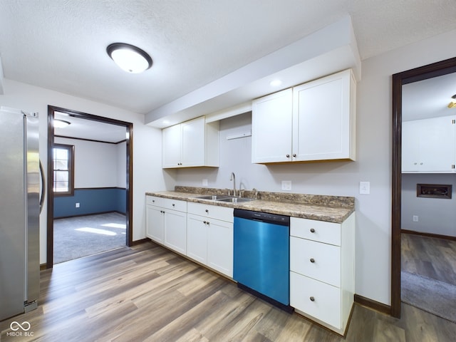 kitchen featuring hardwood / wood-style floors, white cabinetry, sink, and stainless steel appliances