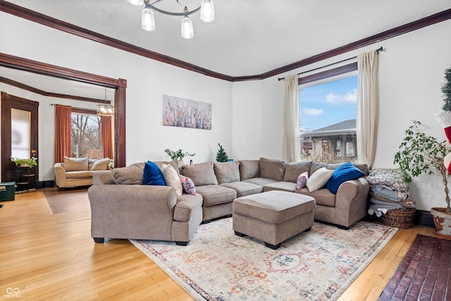 living room featuring wood-type flooring, ornamental molding, a wealth of natural light, and an inviting chandelier