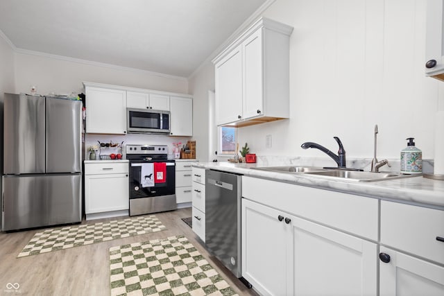 kitchen featuring stainless steel appliances, white cabinetry, and ornamental molding