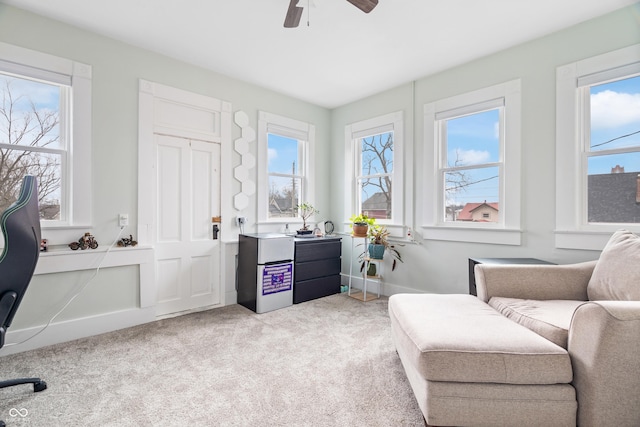 living area with light colored carpet and ceiling fan