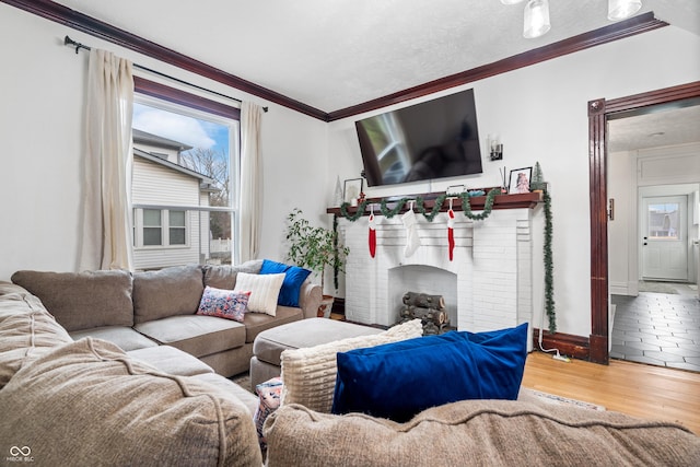 living room with hardwood / wood-style flooring, a brick fireplace, and crown molding