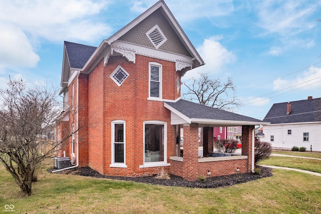 view of side of property featuring a yard, cooling unit, and a porch