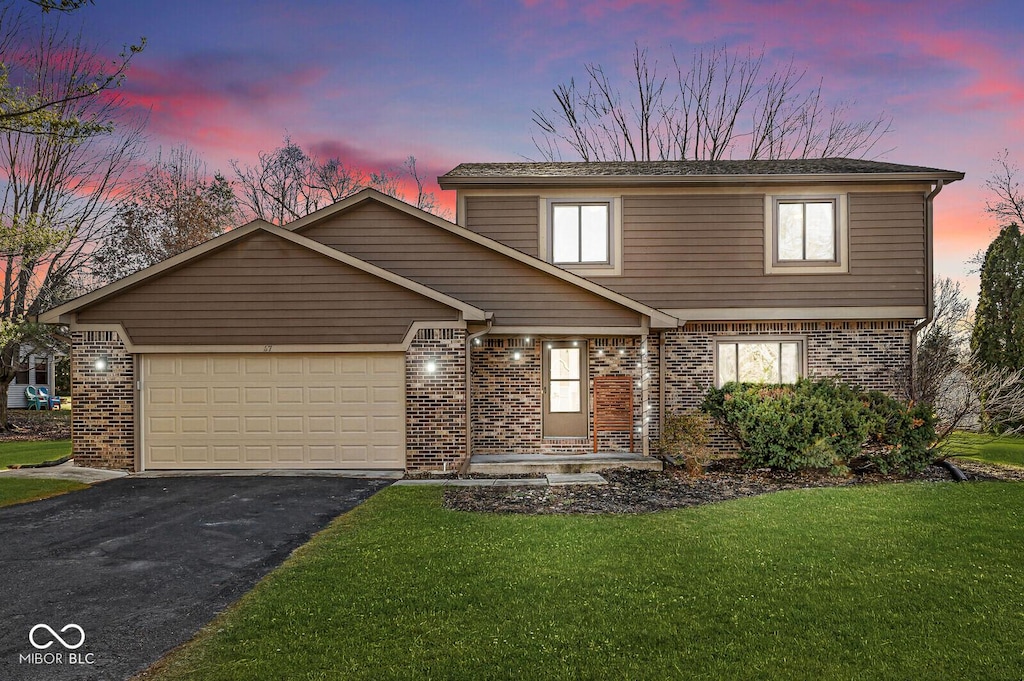 view of front property with a yard and a garage