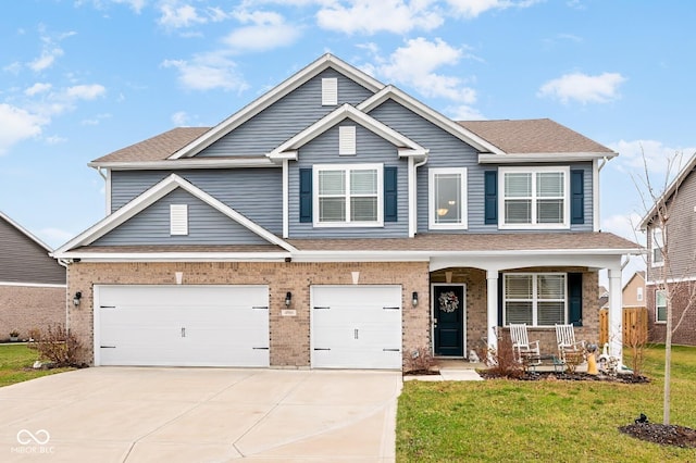 craftsman inspired home with a front yard, a garage, and covered porch