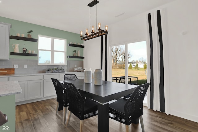 dining area featuring dark hardwood / wood-style floors and an inviting chandelier