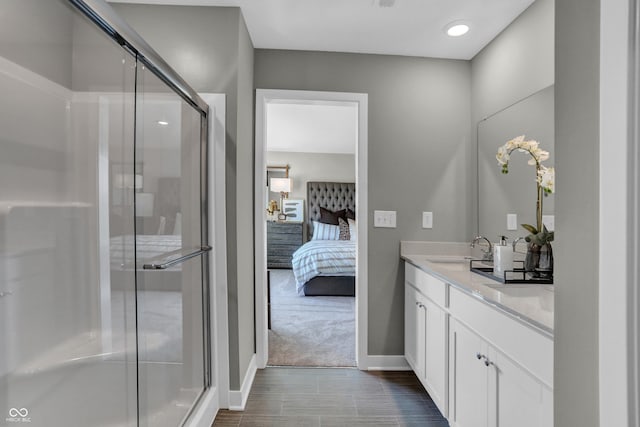 bathroom with hardwood / wood-style floors, vanity, and an enclosed shower