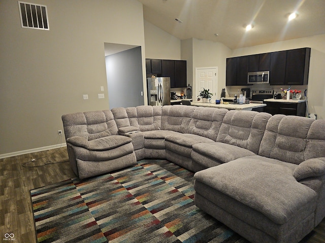 living room featuring high vaulted ceiling and dark hardwood / wood-style floors