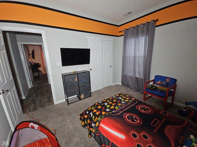 carpeted bedroom featuring ornamental molding, a textured ceiling, and a closet