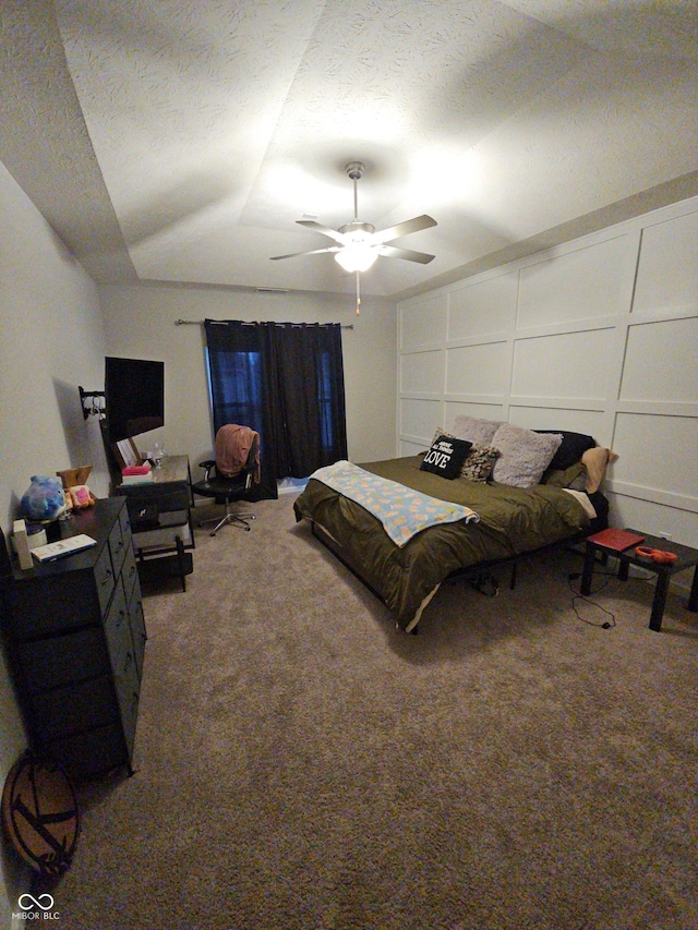 bedroom featuring ceiling fan, carpet floors, and a textured ceiling