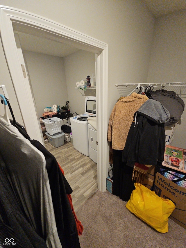 walk in closet with light hardwood / wood-style floors and separate washer and dryer