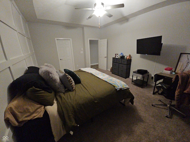 bedroom featuring carpet flooring, ceiling fan, and a raised ceiling