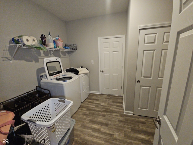 laundry room with washing machine and clothes dryer and dark hardwood / wood-style floors