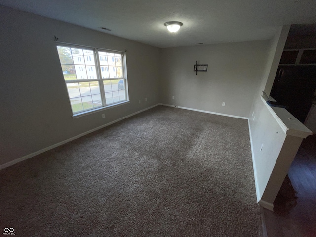 empty room with dark colored carpet