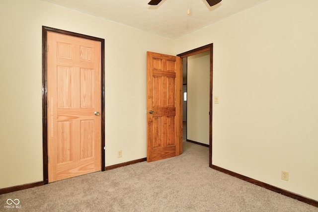 unfurnished bedroom featuring light colored carpet and ceiling fan