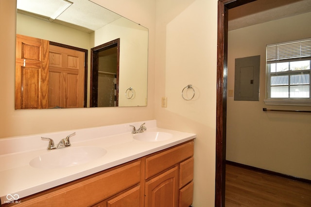 bathroom featuring hardwood / wood-style flooring, vanity, and electric panel