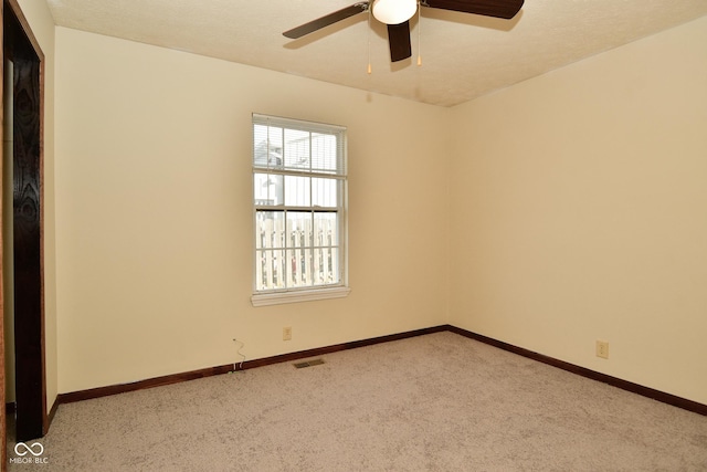 empty room featuring light carpet, a textured ceiling, and ceiling fan