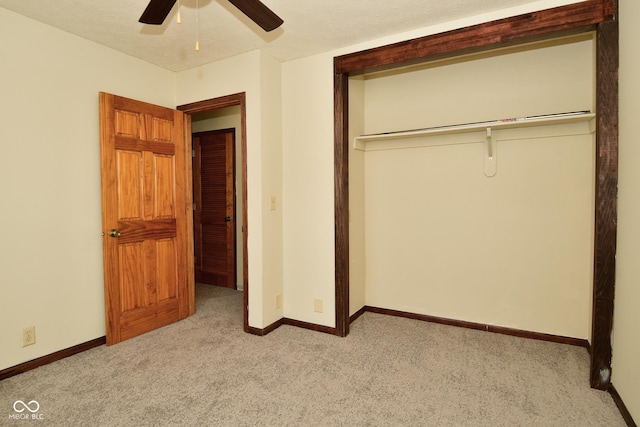 unfurnished bedroom featuring ceiling fan, a closet, light carpet, and a textured ceiling