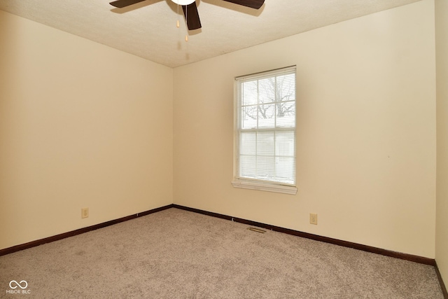 carpeted spare room with ceiling fan