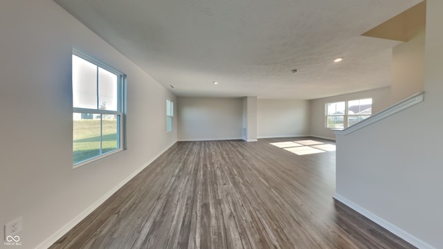 empty room featuring a textured ceiling and dark wood-type flooring