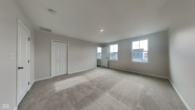 unfurnished room featuring light carpet