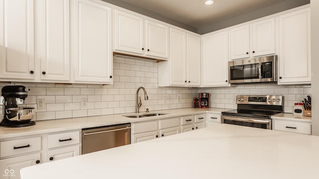 kitchen featuring backsplash, stainless steel appliances, white cabinetry, and sink