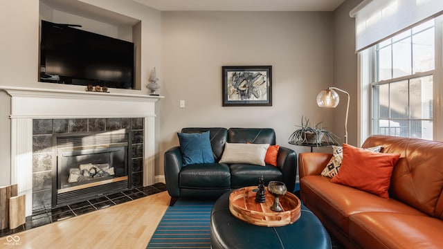 living room with a wealth of natural light, a fireplace, and dark hardwood / wood-style floors