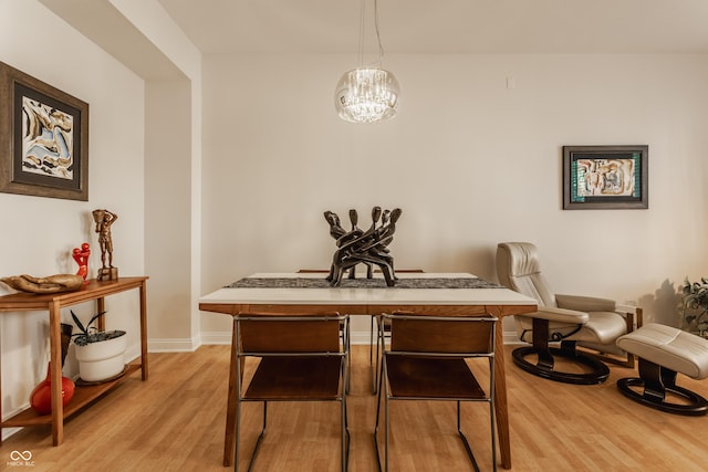 dining room featuring light wood-type flooring and an inviting chandelier