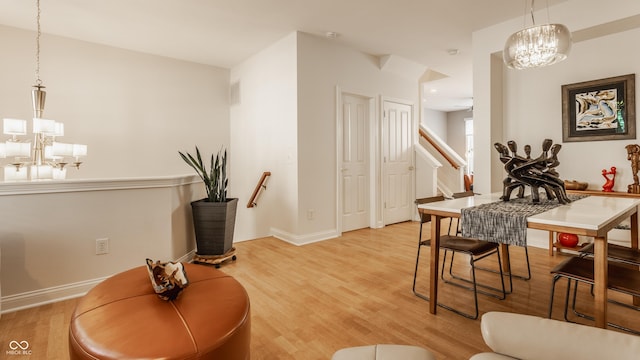 interior space featuring ceiling fan with notable chandelier and light hardwood / wood-style floors