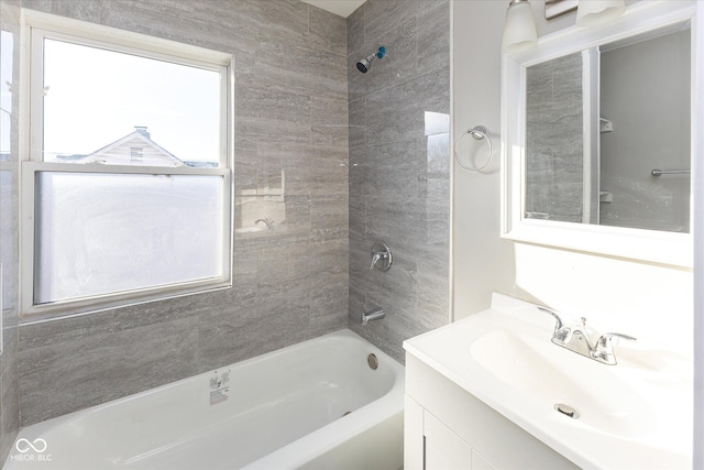 bathroom featuring tiled shower / bath combo, a healthy amount of sunlight, and vanity