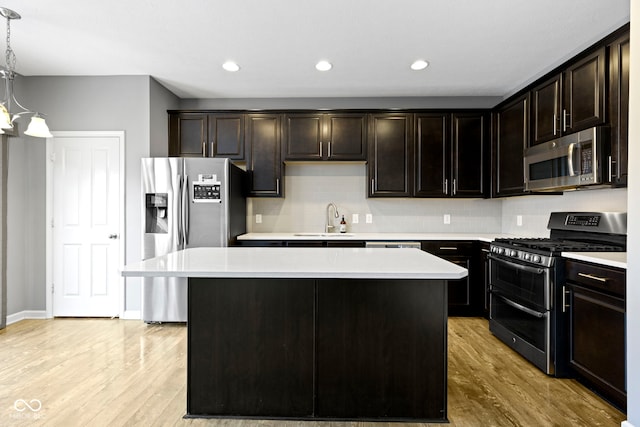 kitchen featuring sink, hanging light fixtures, a center island, and stainless steel appliances