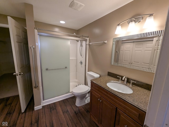 bathroom featuring an enclosed shower, vanity, wood-type flooring, and toilet