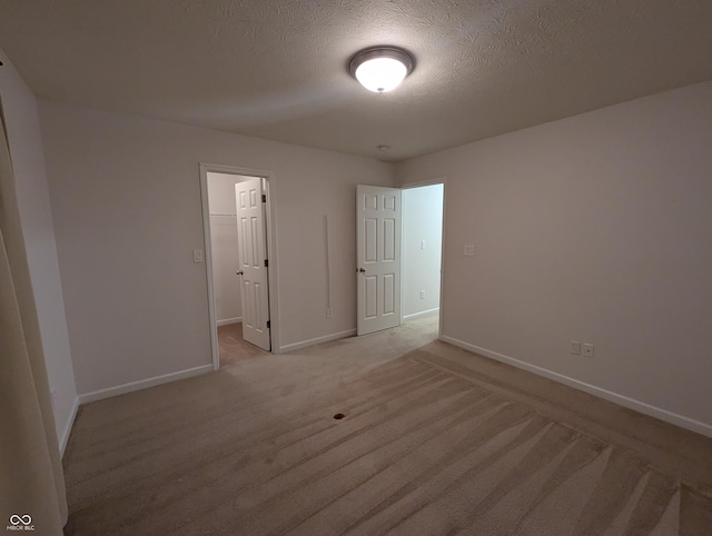 carpeted spare room with a textured ceiling