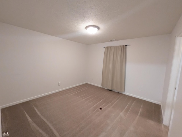 empty room featuring carpet flooring and a textured ceiling