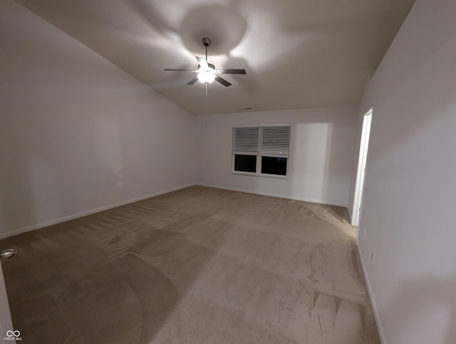 carpeted empty room featuring vaulted ceiling and ceiling fan