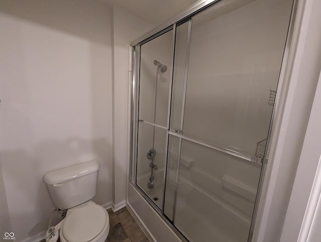 bathroom with enclosed tub / shower combo and toilet