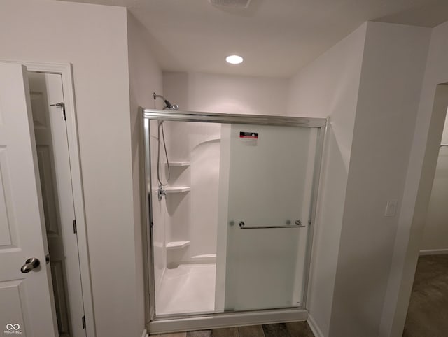 bathroom featuring hardwood / wood-style flooring and walk in shower