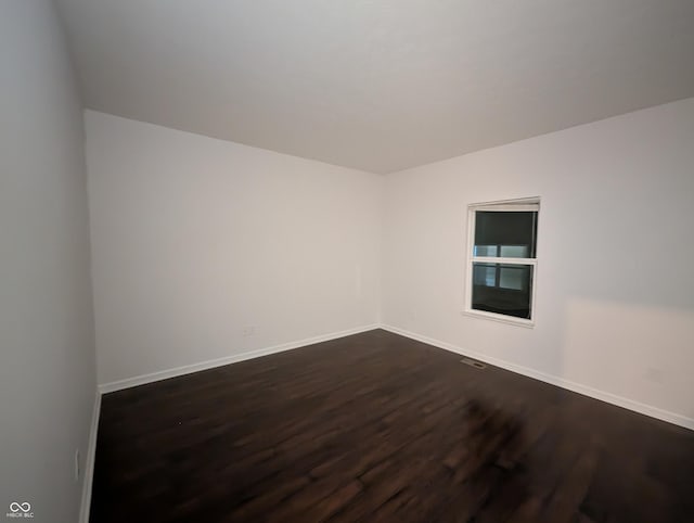 spare room featuring dark wood-type flooring