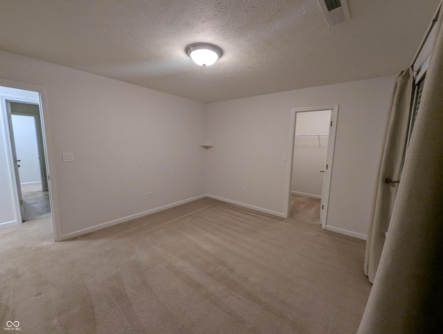 carpeted spare room featuring a textured ceiling