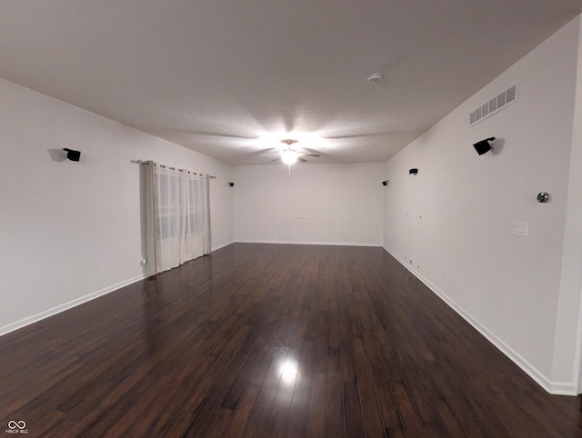 spare room featuring dark wood-type flooring and ceiling fan