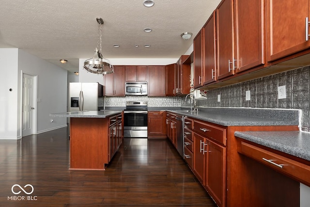 kitchen featuring dark wood-style floors, a center island, backsplash, appliances with stainless steel finishes, and a sink